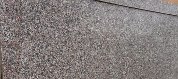 Cheema granite: a fine rose-brown and grey speckled polished slab face, from a stack in the showroom