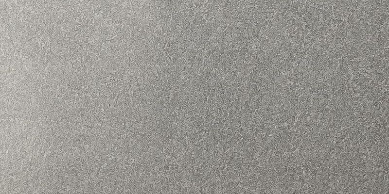 Sheera Grey granite: an even silver-grey surface with a fine, densely packed mineral grain, polished to a soft sheen