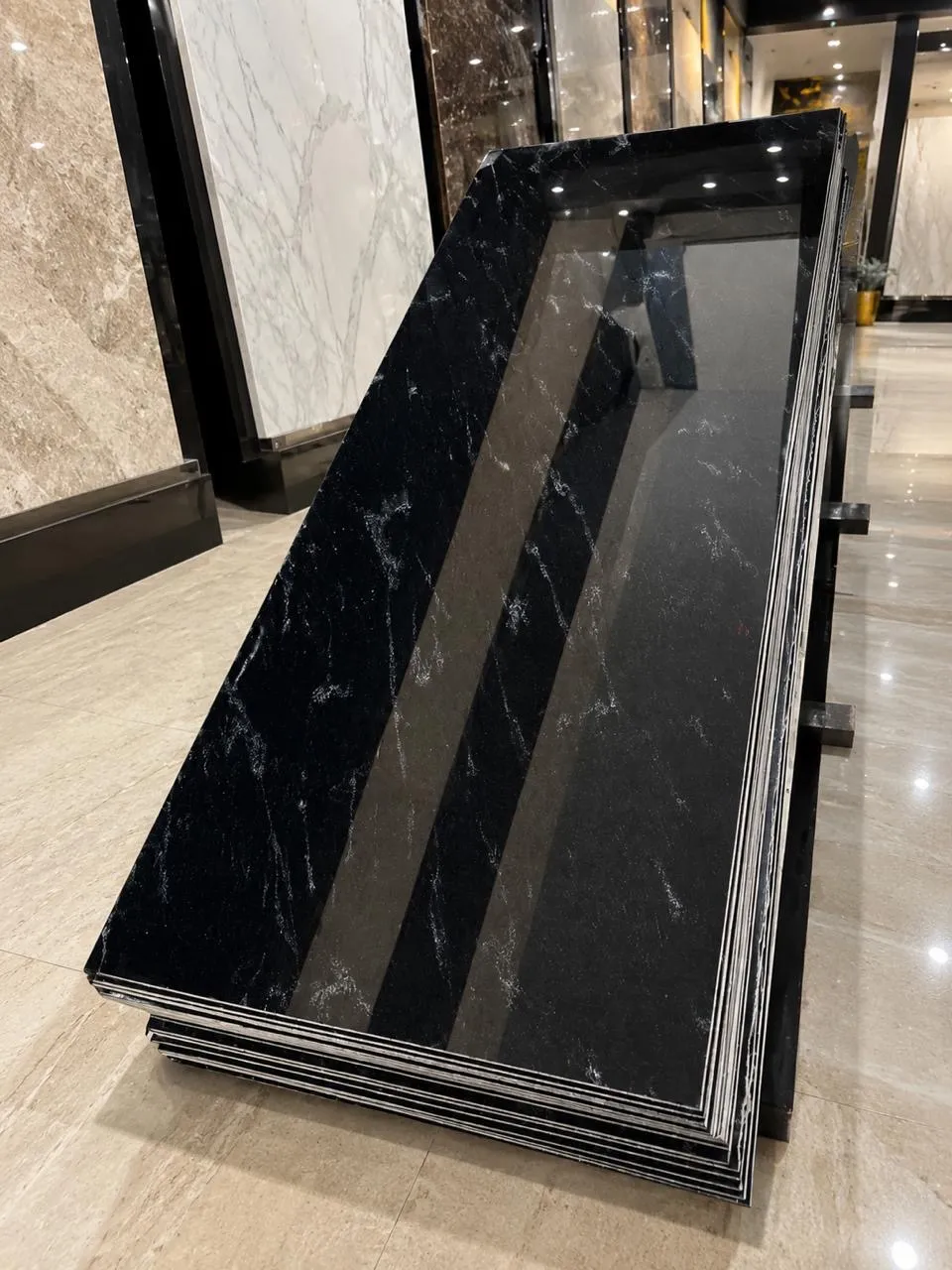 A stack of polished black slabs with fine white veining in the showroom