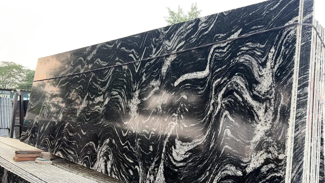 Polished black-and-white veined slabs racked in the yard