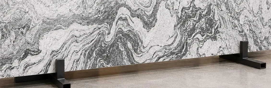 Viscon White granite: bright white surface with flowing grey and charcoal swirls, like a river in stone