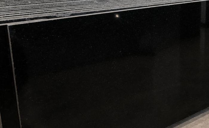Z Black granite: stacks of polished deep-black slabs with a clean, even sheen, photographed in the showroom
